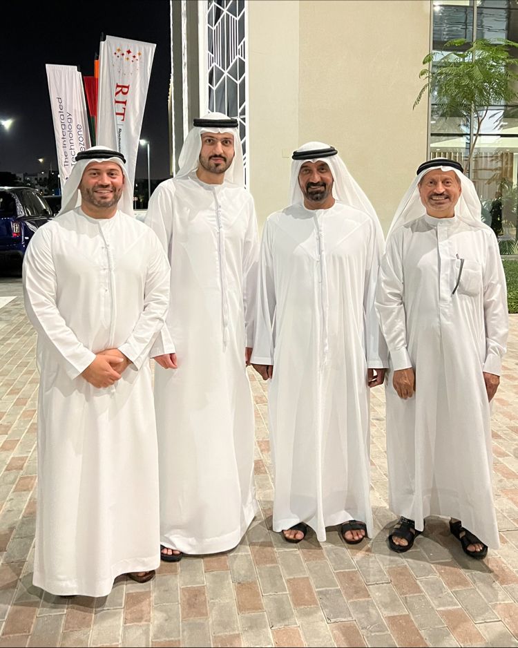 Four Emirati businessmen in traditional dress standing together at an evening business event in the United Arab Emirates